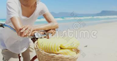 活跃的非裔美国妇女靠在海滩上的自行<strong>车把手</strong>的正面景色